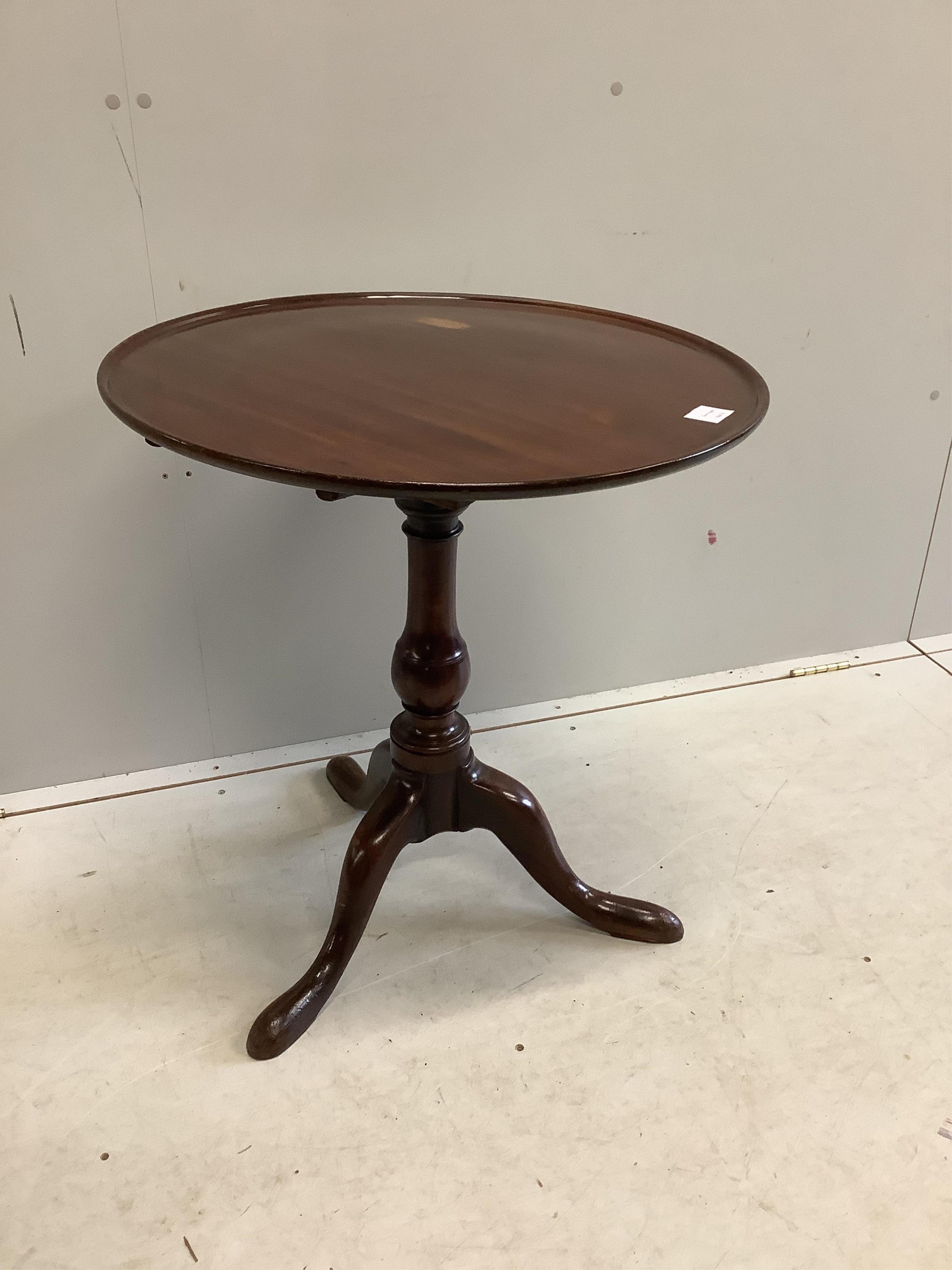 A George III circular mahogany tilt top tripod tea table, diameter 63cm, height 69cm. Condition - fair